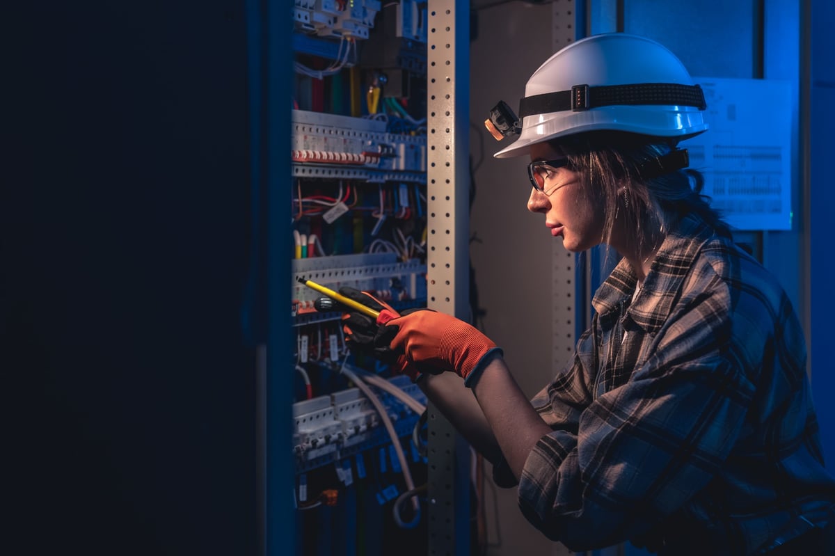 Professional female engineer working safely with electrical equipment